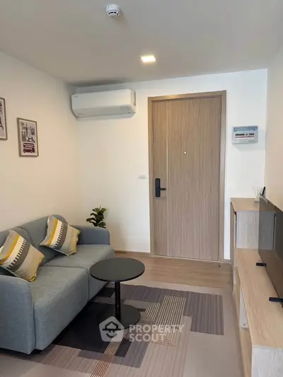 Modern living room with cozy sofa, stylish decor, and sleek air conditioning unit.
