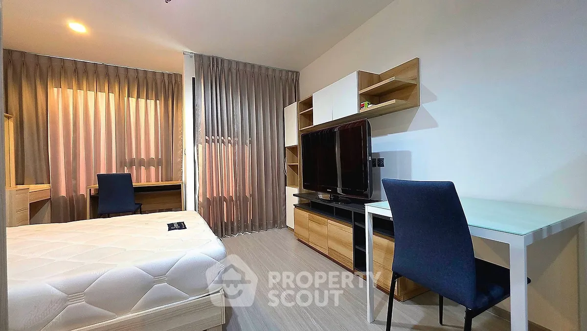 Modern bedroom with study area, featuring sleek furniture and natural light for a cozy and functional living space.