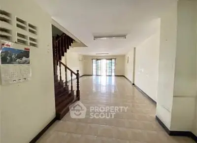 Spacious open-plan living area with staircase and large windows