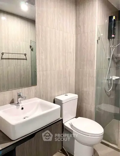 Modern bathroom with sleek fixtures and glass shower enclosure in a contemporary apartment.