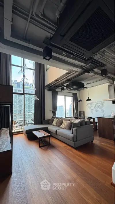 Spacious modern living room with high ceilings and city view, featuring stylish decor and open layout.
