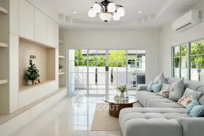 Elegant living room with plush sofa, modern lighting, and garden view through large windows.