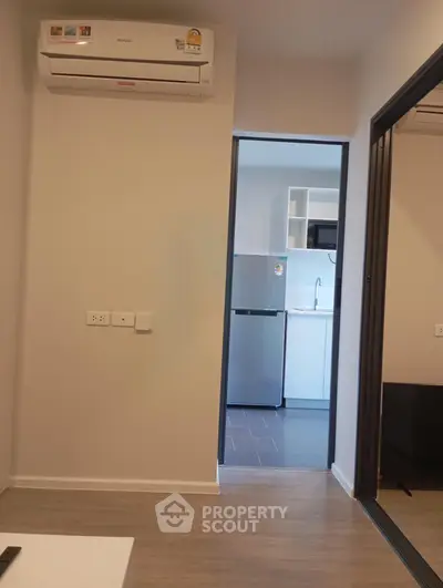 Modern apartment interior with air conditioning and sleek kitchen appliances.
