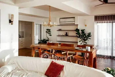 Spacious living room with elegant dining area and natural light, featuring modern decor and cozy ambiance.
