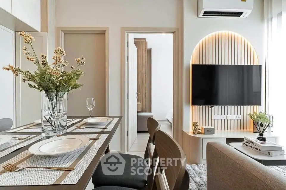 Modern living room with stylish decor and wall-mounted TV, featuring elegant dining setup and cozy ambiance.