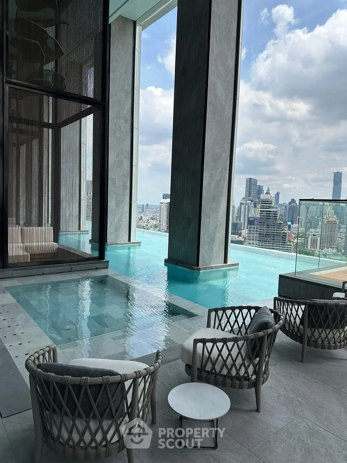 Luxurious rooftop pool with stunning city skyline views and elegant seating area.