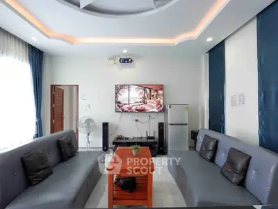 Modern living room with stylish ceiling, cozy sofas, and entertainment setup.