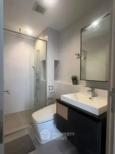 Modern bathroom with sleek fixtures and glass shower enclosure