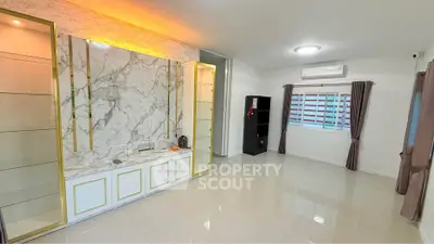 Spacious modern living room with marble accent wall and elegant lighting
