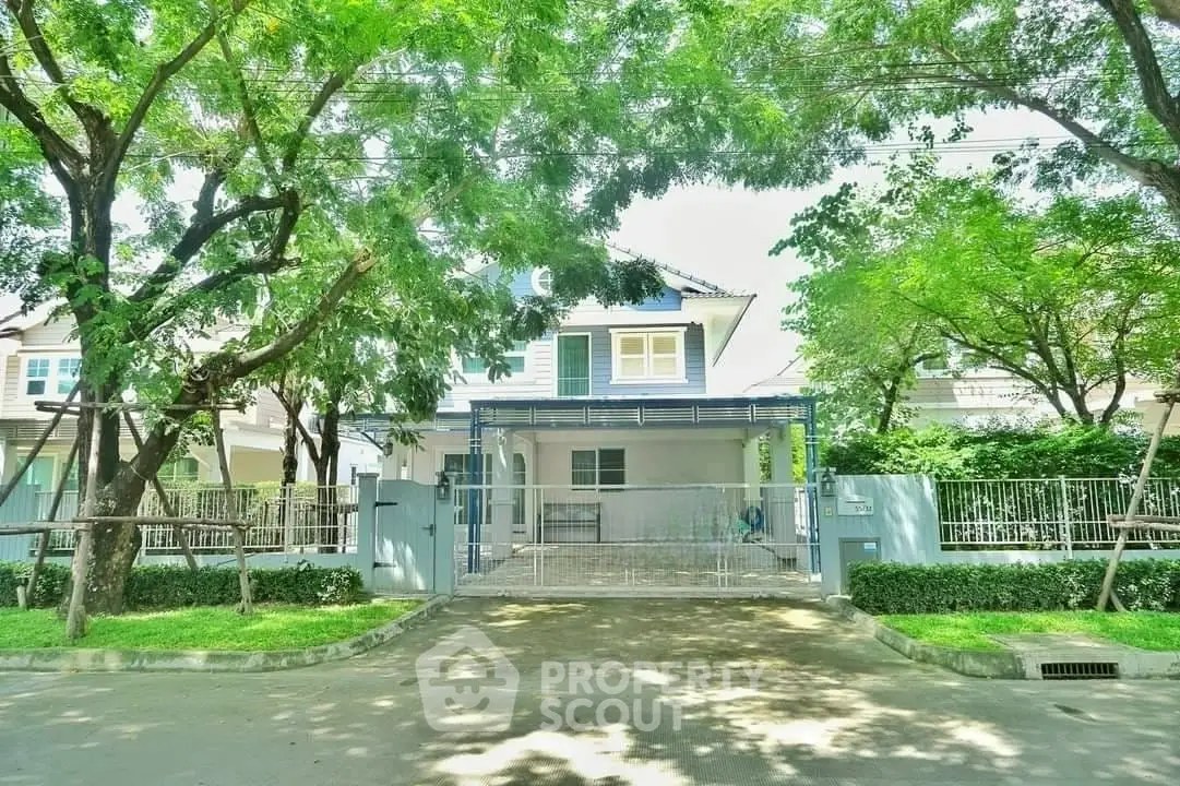 Charming suburban house with lush greenery and spacious driveway.