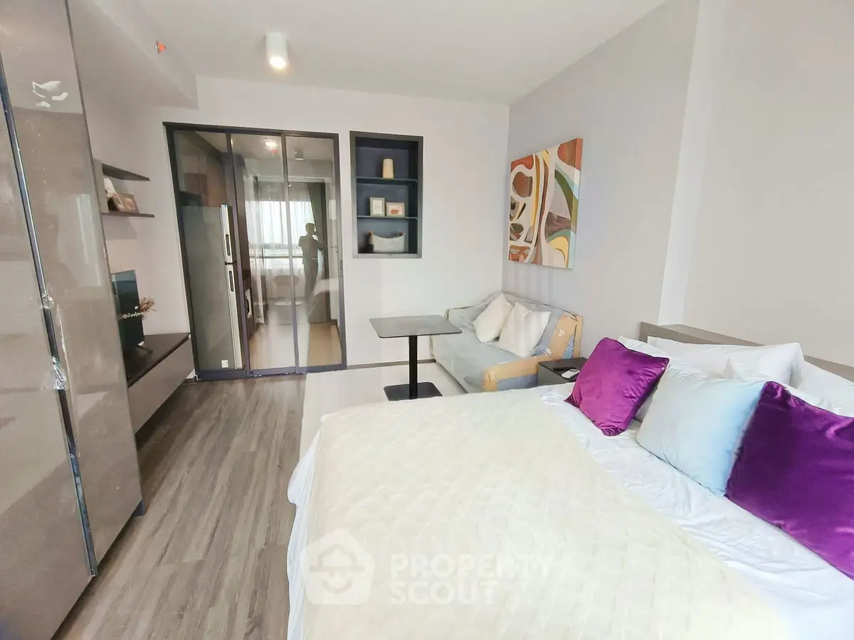 Modern studio apartment with stylish decor and open layout, featuring a cozy bed and sleek furniture.