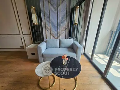 Modern living room with stylish sofa and elegant coffee tables near large windows.