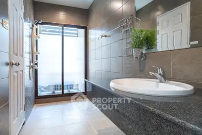Modern bathroom with sleek design and large window for natural light.