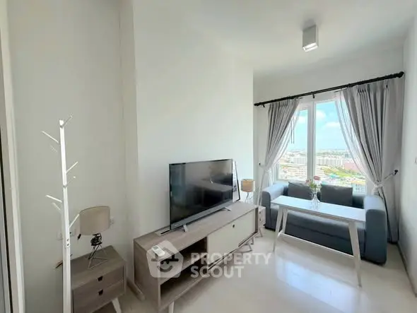 Modern living room with large window offering stunning city views, stylish furniture, and natural light.