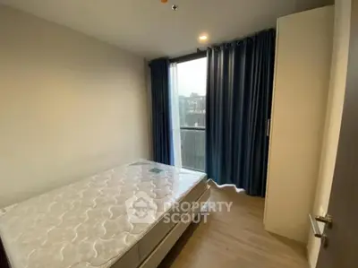 Cozy bedroom with large window and blue curtains in modern apartment