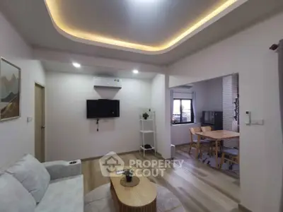 Modern living room with stylish ceiling lights and open dining area