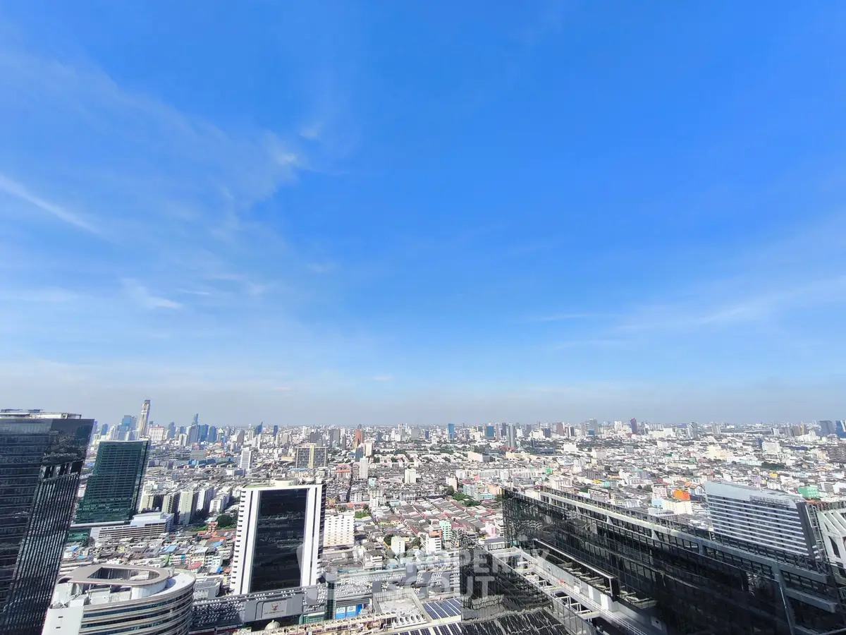 Stunning cityscape view from a high-rise building, showcasing urban skyline under a clear blue sky.