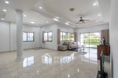 Spacious living room with elegant columns and large windows offering natural light.