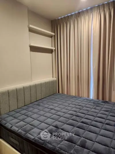 Cozy bedroom with elegant curtains and modern shelving, perfect for restful nights.