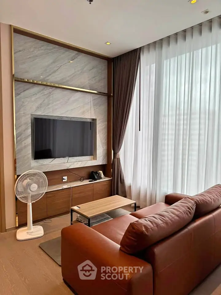 Modern living room with elegant decor, featuring a sleek TV setup and comfortable seating.