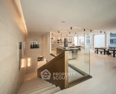 Luxurious open-plan living space with modern staircase and elegant dining area.