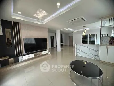 Spacious modern living room with sleek design and large TV setup.