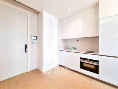 Modern kitchen with sleek white cabinets and built-in appliances in a bright apartment.