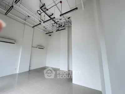 Spacious modern interior with high ceilings and industrial lighting, perfect for versatile use.