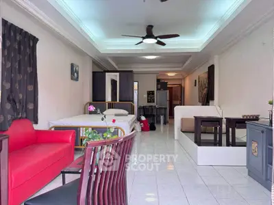 Spacious open-layout living area with modern furniture and ceiling fan, perfect for comfortable urban living.