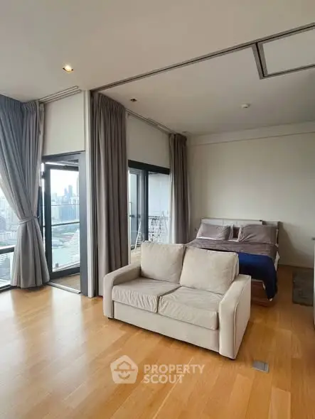 Spacious bedroom with city view and cozy seating area in modern apartment.
