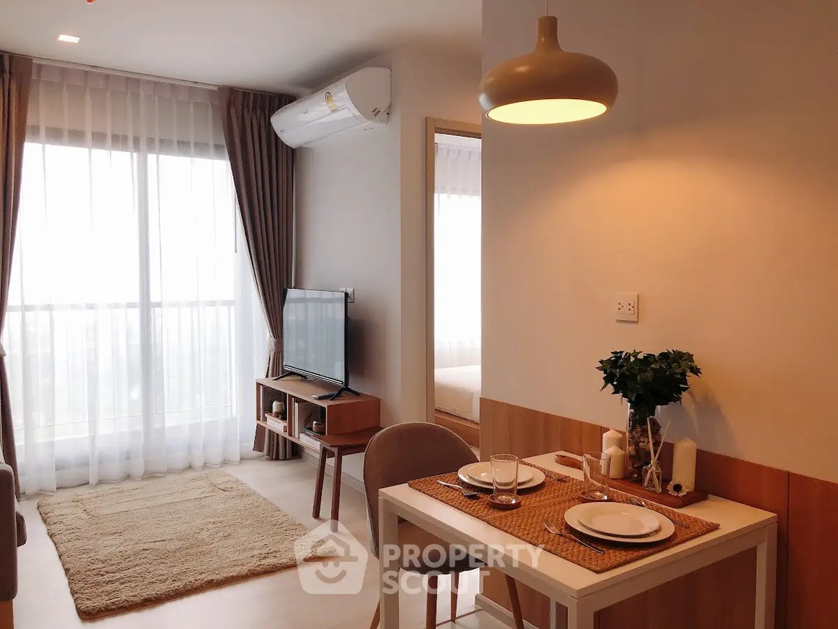 Modern living room with dining area and large window in cozy apartment