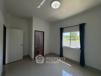 Spacious bedroom with natural light and ensuite bathroom in modern home