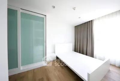Spacious minimalist bedroom with large window and sliding closet doors