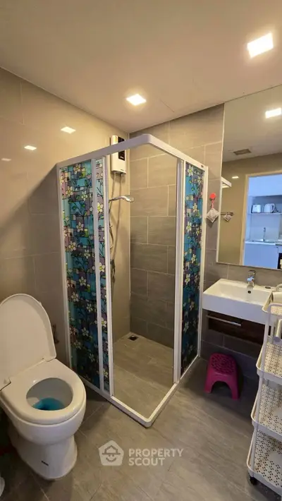 Modern bathroom with shower enclosure and sleek fixtures in a contemporary apartment.