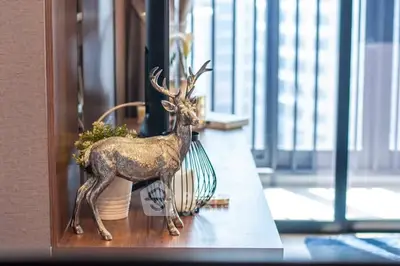 Stylish interior decor with a silver deer statue and modern furnishings near a balcony.