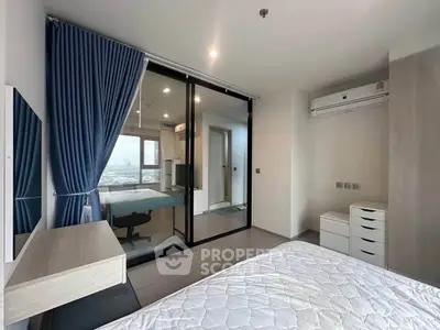 Modern bedroom with large window and city view, featuring sleek furniture and air conditioning.