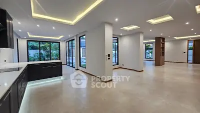 Spacious modern open-plan living area with sleek kitchen and large windows.