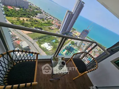 Stunning high-rise balcony with breathtaking ocean view and cozy seating area.