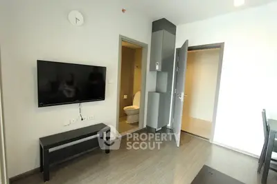 Modern apartment interior with wall-mounted TV and open bathroom door