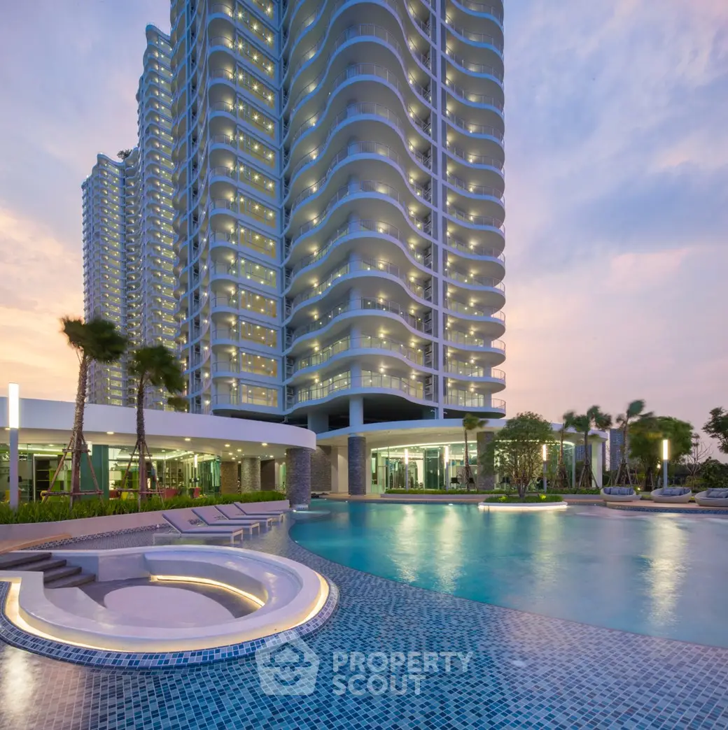 Luxurious high-rise building with stunning pool and modern architecture at sunset.