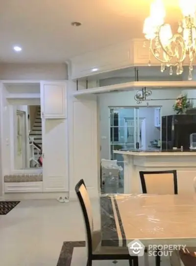 Elegant dining area with chandelier and open kitchen layout