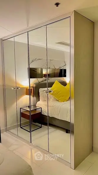 Modern bedroom with mirrored wardrobe and cozy lighting