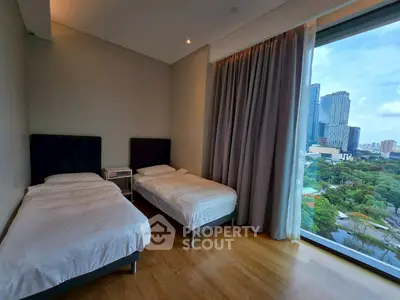 Modern bedroom with twin beds and stunning city view through large window.