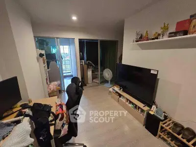 Modern living room with sleek TV setup and balcony view, perfect for urban living.