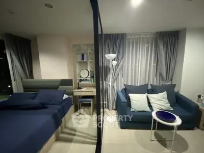 Modern studio apartment with cozy bed and stylish living area, featuring elegant decor and ample natural light.