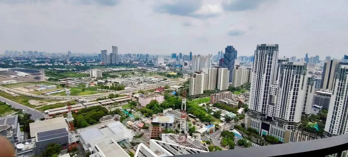 Stunning cityscape view from a high-rise balcony showcasing urban skyline and green spaces.
