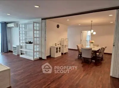 Spacious open-plan living and dining area with elegant hardwood floors and modern furnishings.