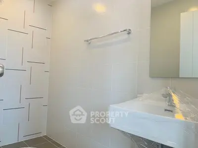 Modern bathroom with sleek tiles and a stylish sink, perfect for contemporary living.