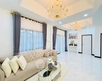 Luxurious living room with elegant chandeliers and plush sofa in a modern home.