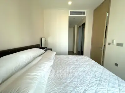 Modern bedroom with cozy bedding and sleek design in a contemporary apartment.